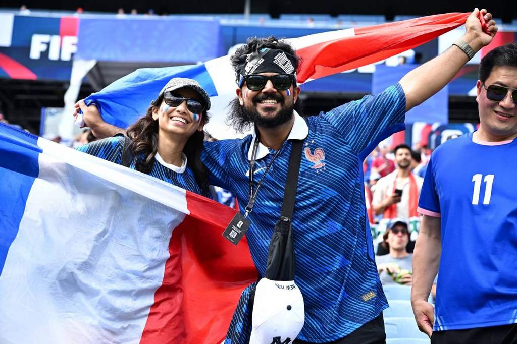 French football fans cheering inside a crowded stadium