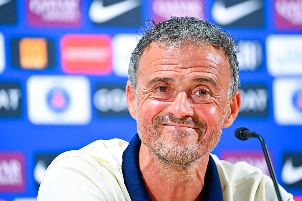 Luis Enrique smiling on the Paris Saint-Germain bench during a match.